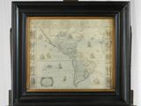 Une vieille carte du monde est exposée dans un cadre en bois.