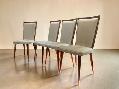 three chairs with upholstered seats sit in a row on a concrete floor