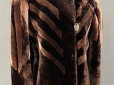 une photo d'un manteau marron et noir posé sur un présentoir pour mannequin