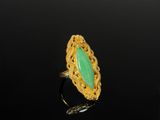 a gold ring with a green stone in the center