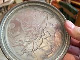 a person holding a silver plate in their hand