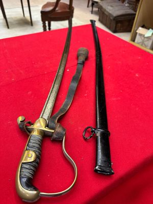pair of swords on a red table cloth with a chair in the background