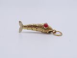 a gold fish charm with a red stone on it