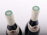 two bottles of wine sitting next to each other on a table