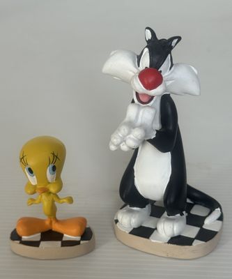 deux figurines représentant des insectes et un chat posées sur une table