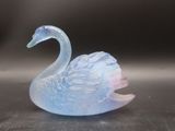 une figurine de cygne en verre posée sur une table