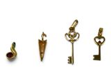 four different types of gold charms on a white background