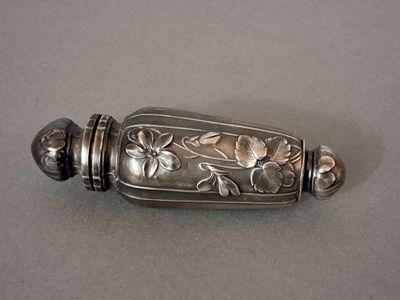 a silver object with flowers on it on a table