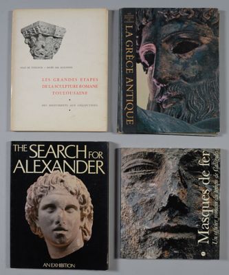 quatre livres posés sur une table, à côté d'une statue représentant le visage d'un homme