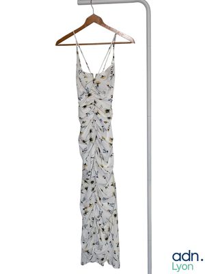une robe blanche suspendue à un portant, à côté d'un cintre