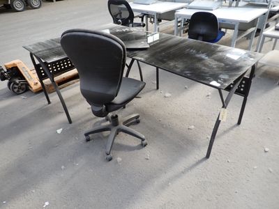 une table avec une chaise et une table sur laquelle se trouve un ordinateur portable