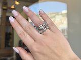 woman ' s hand holding a diamond ring in front of a mirror