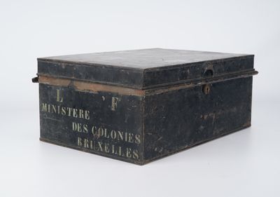 une vieille boîte noire posée sur une surface blanche
