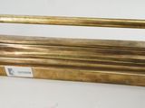 three brass handles on a wall mounted rack
