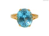 Gros plan sur une bague en or ornée d'une topaze bleue