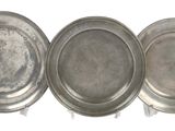 three silver trays sitting on top of each other on a white surface