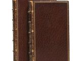 an old book with a pen sitting on top of it