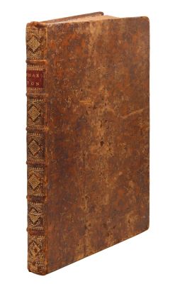 un vieux livre à la couverture brune posé sur une surface blanche