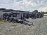 plusieurs piles de bois empilées les unes sur les autres devant un bâtiment