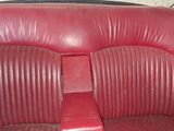 an image of a red leather car seat with a clock in the background
