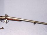 un vieux fusil avec un canon en bois et un étui vert