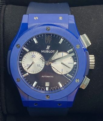 a close up of a blue watch on a black watch band