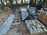 un tas de briques posé par terre à côté d'un tas de palettes