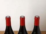 three bottles of wine sitting on top of a table next to each other