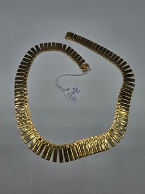 un collier en or sur fond blanc, muni d'une étiquette
