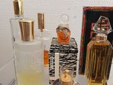 many different types of perfumes on a glass shelf