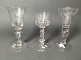 three glass goblets sitting next to each other on a table