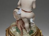porcelain figurine of a boy with a dog on a pedestal
