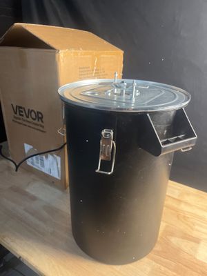 un pot noir posé sur une table en bois à côté d'une boîte