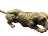a statue of a dog laying down on a white surface
