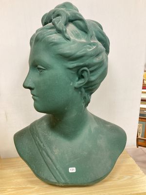 un buste représentant une femme en robe verte, assise sur une table en bois