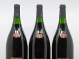 trois bouteilles de vin sont alignées sur une surface blanche