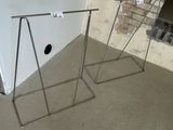 two metal stands in front of a brick wall