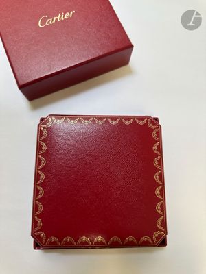 une boîte rouge ouverte posée sur une table, à côté d'une boîte rouge