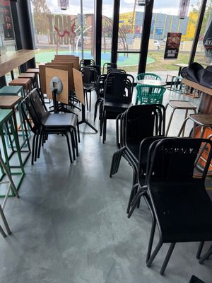 de nombreuses chaises et tables dans une pièce dotée de nombreuses fenêtres