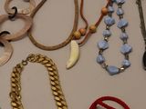 many necklaces and bracelets laid out on a table