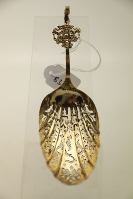 une cuillère en or exposée dans une vitrine