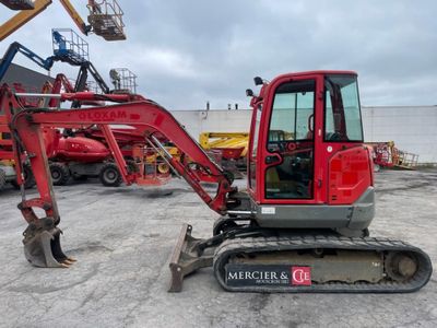 a red excavator that is parked in a parking lot