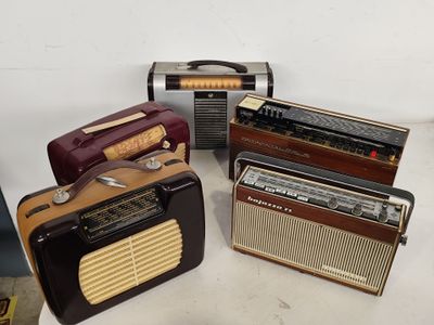 Plusieurs radios à l'ancienne sont posées sur une surface blanche