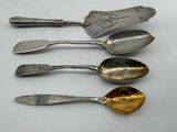 four spoons and a spoon rest on a white surface