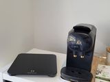 a coffee maker on a white shelf next to a tv