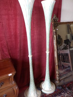 two tall vases sitting next to a mirror in a room