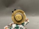 a figurine of a woman with a hat on her head