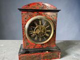 une horloge rouge et noire posée sur une table