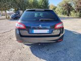 the back end of a black car parked in a parking lot