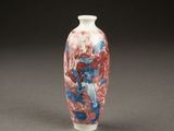 a red and blue vase sitting on a table
